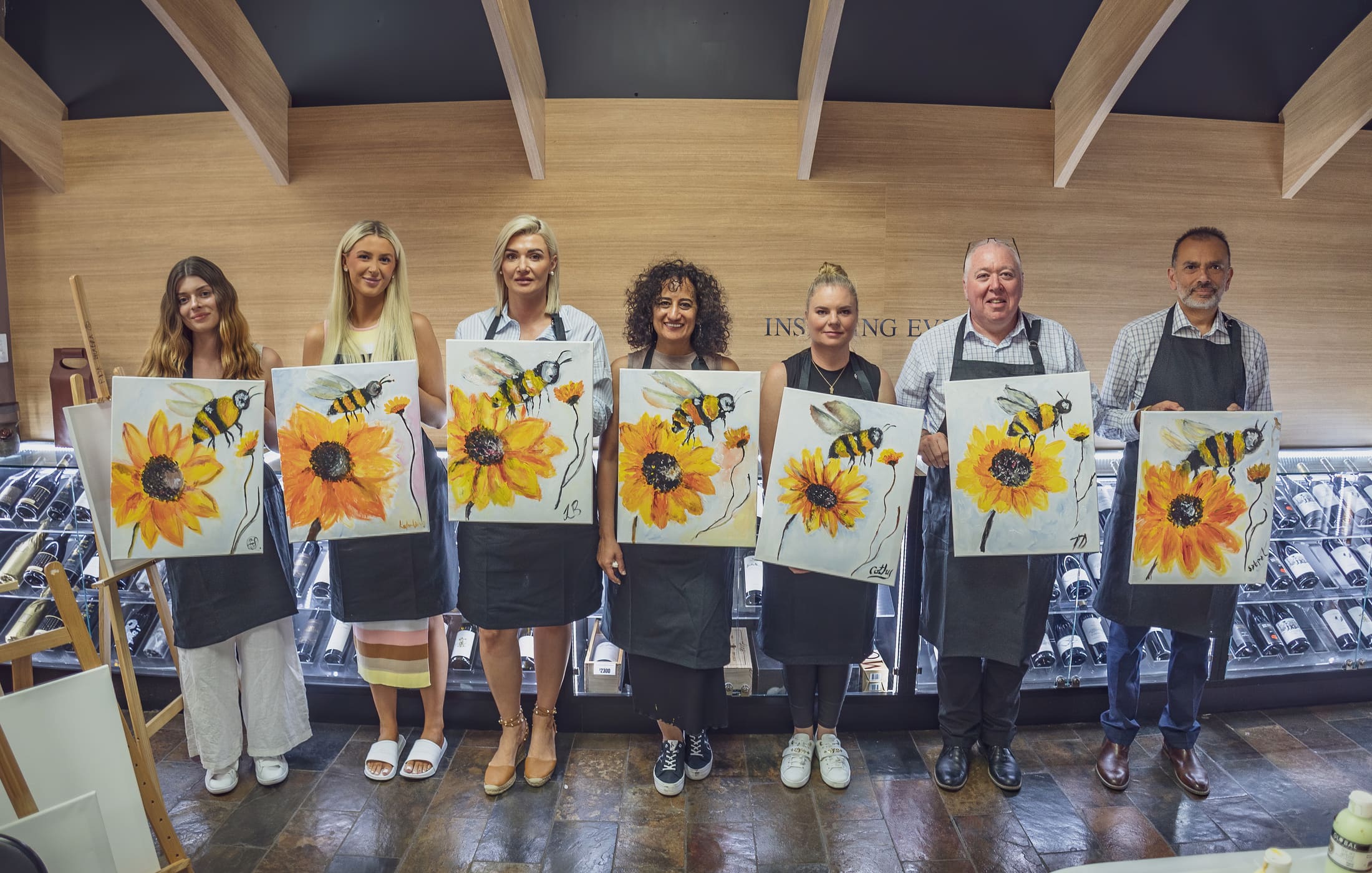 Guests painting sunflowers at easels during a Taste and Paint session